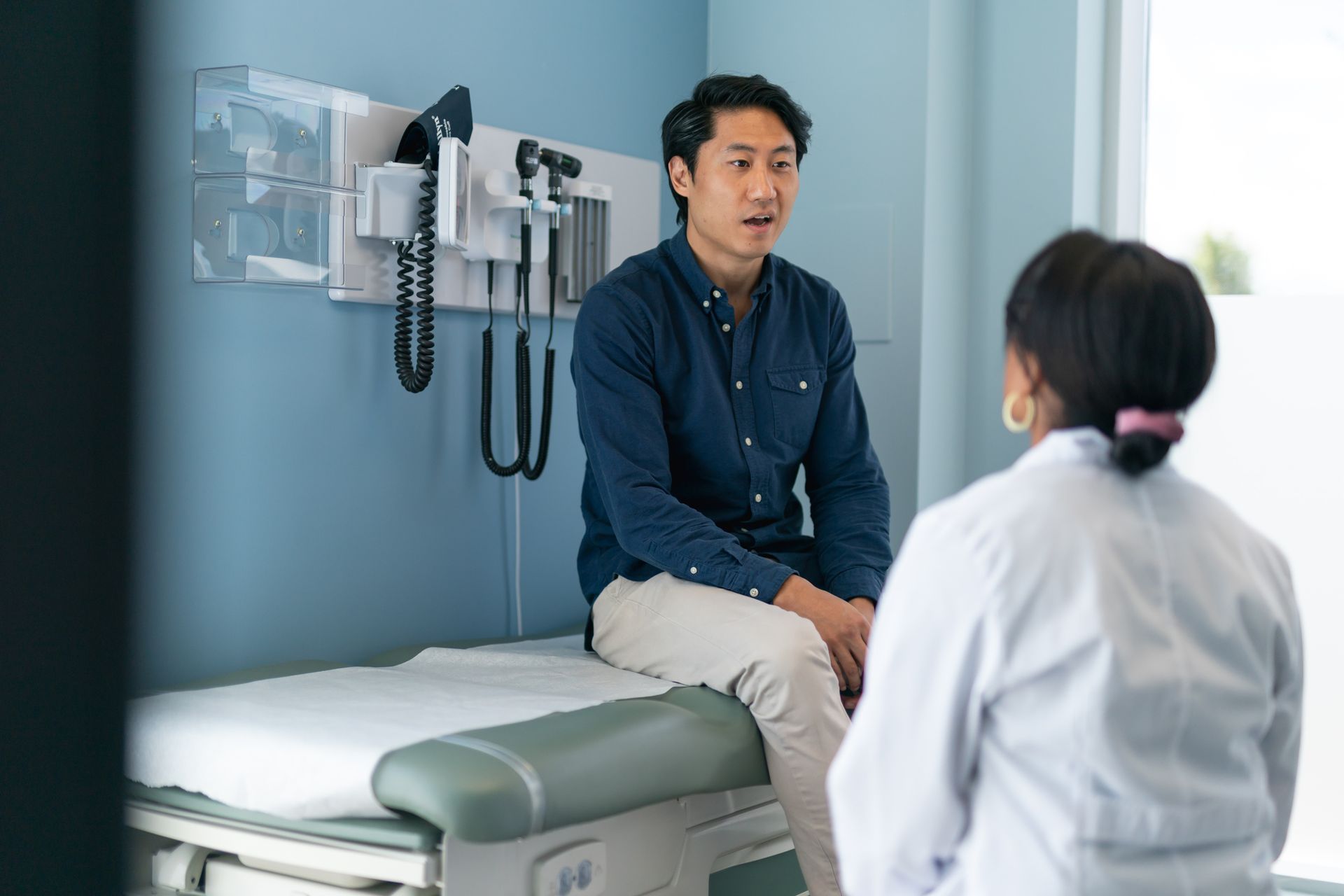 A man in a doctor's office, engaged in a conversation about male testosterone therapy near Carmel, I