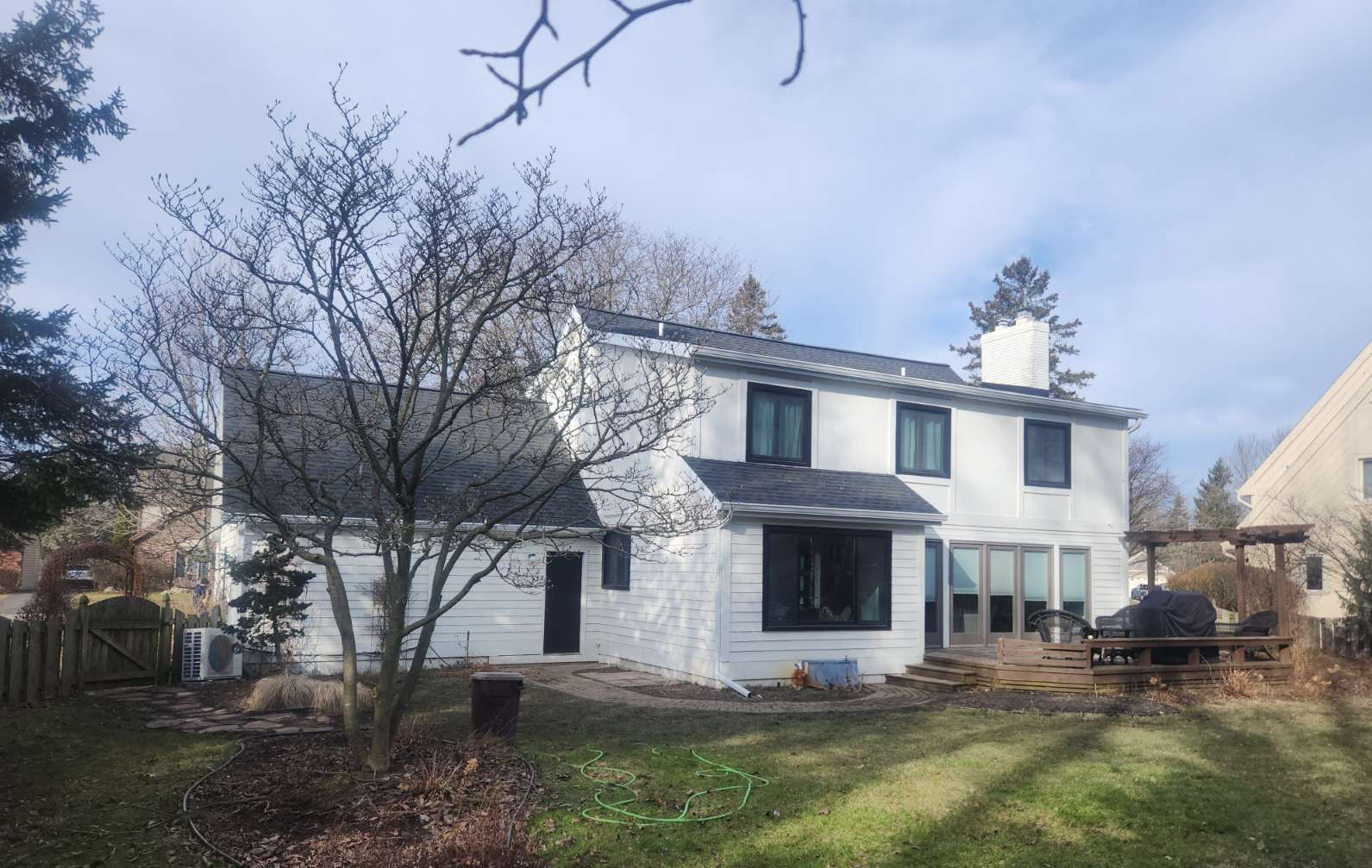 The back of a white house with a black roof