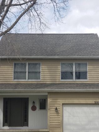 A house with a gray roof and a white garage door.