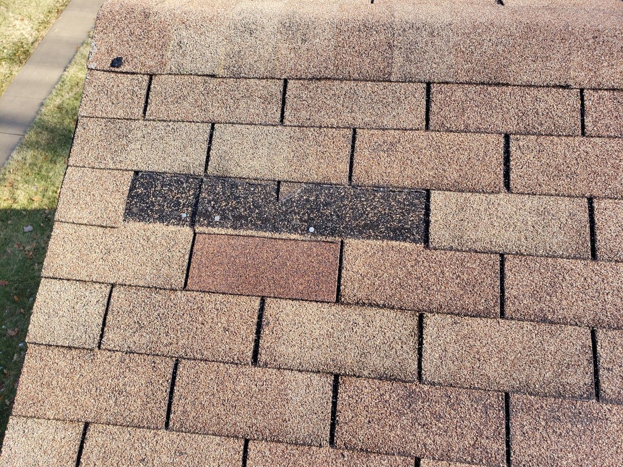 A close up of a roof with a broken shingle