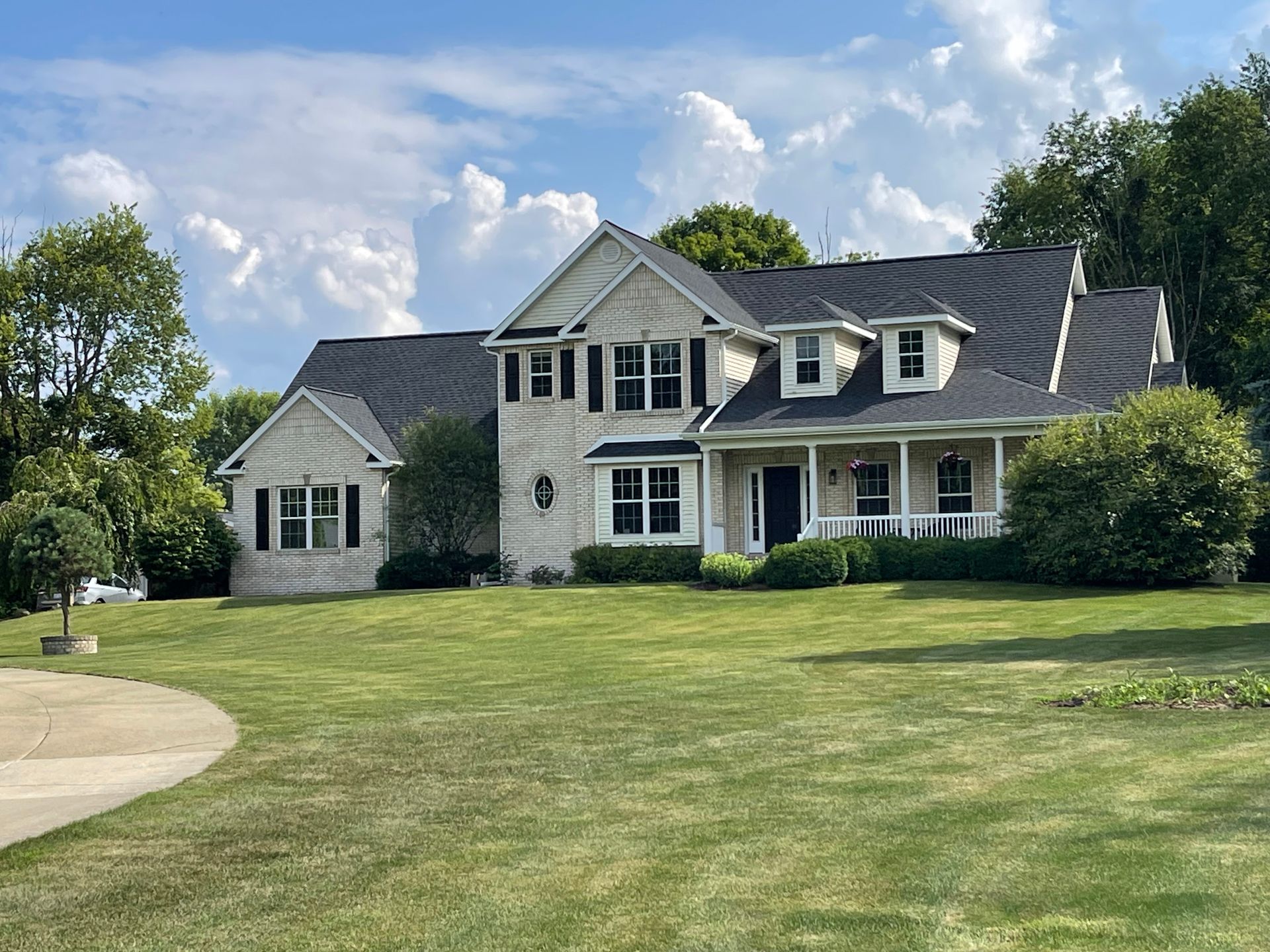 A large white house with a large lawn in front of it.