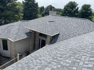 The roof of a house with a gray shingle roof.