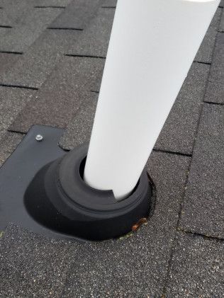 A white pipe is sitting on top of a roof.