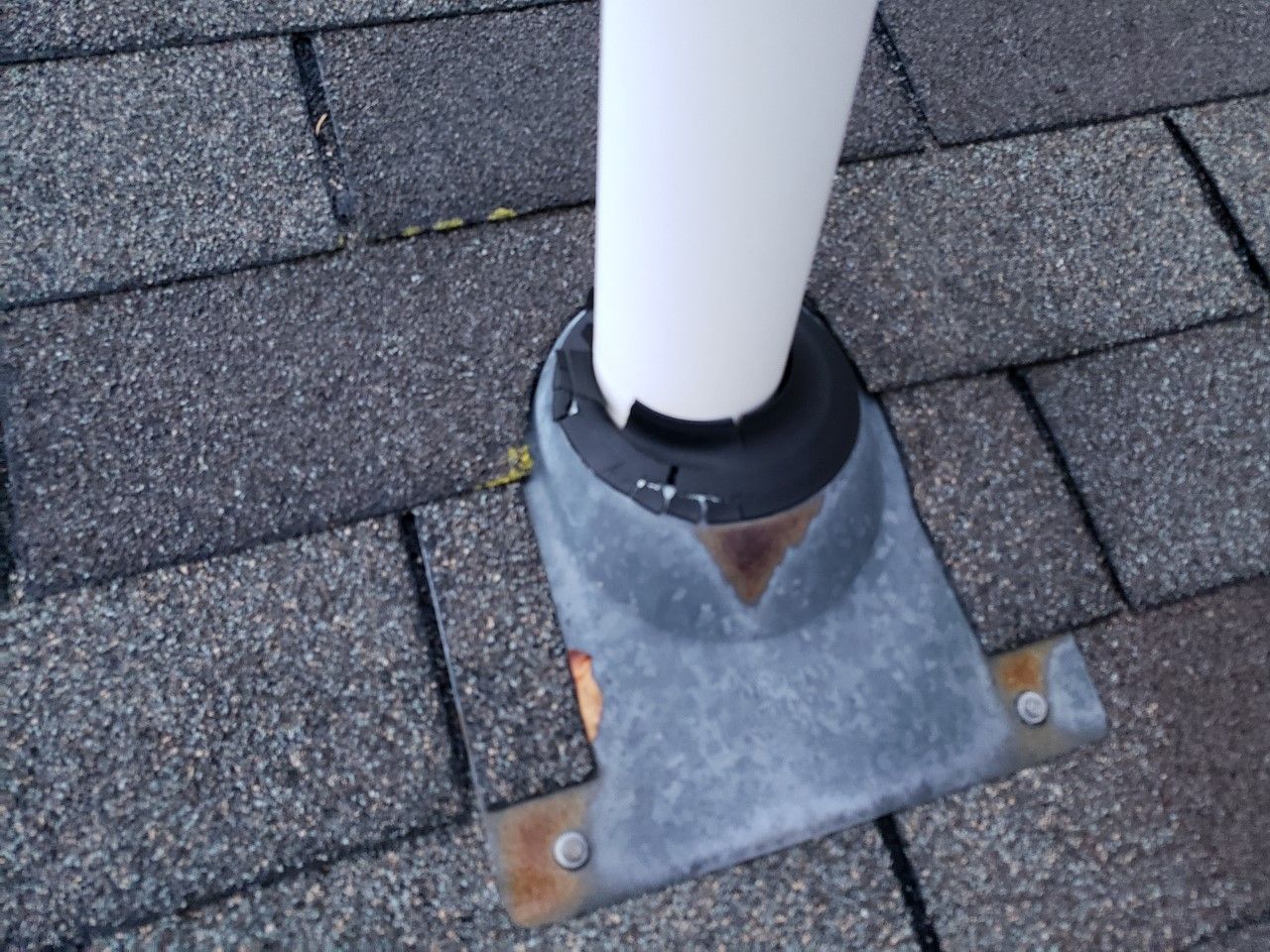 A white pipe is sitting on top of a brick roof