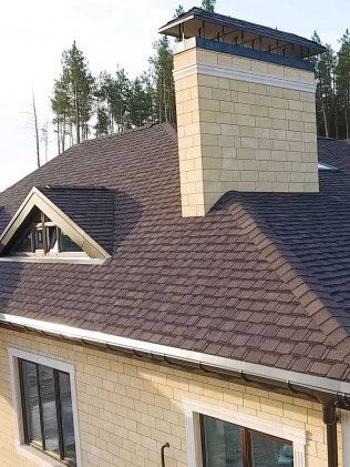 A brick house with a chimney on the roof.