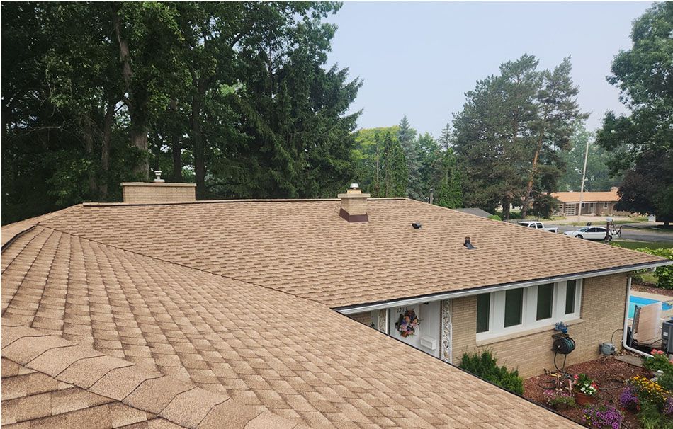 A house with a brown roof and a chimney on top of it.