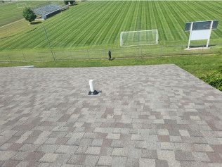 An aerial view of a roof with a soccer field in the background.