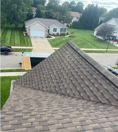 An aerial view of a roof of a house in a residential neighborhood.