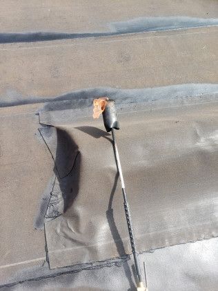 A torch is sitting on top of a roof with a hole in it.