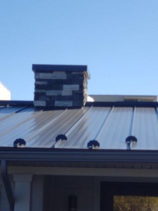 A metal roof with a chimney on top of it