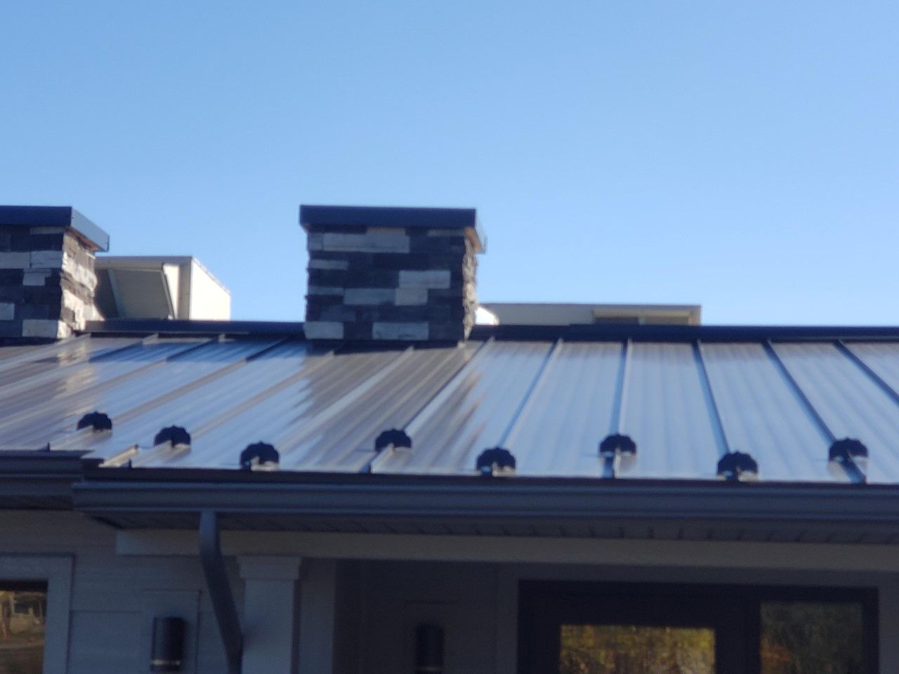 A metal roof with a chimney on top of it