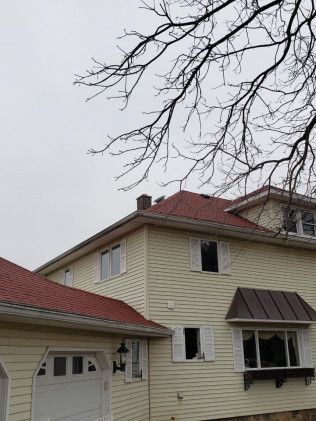 A house with a red roof and a white garage door