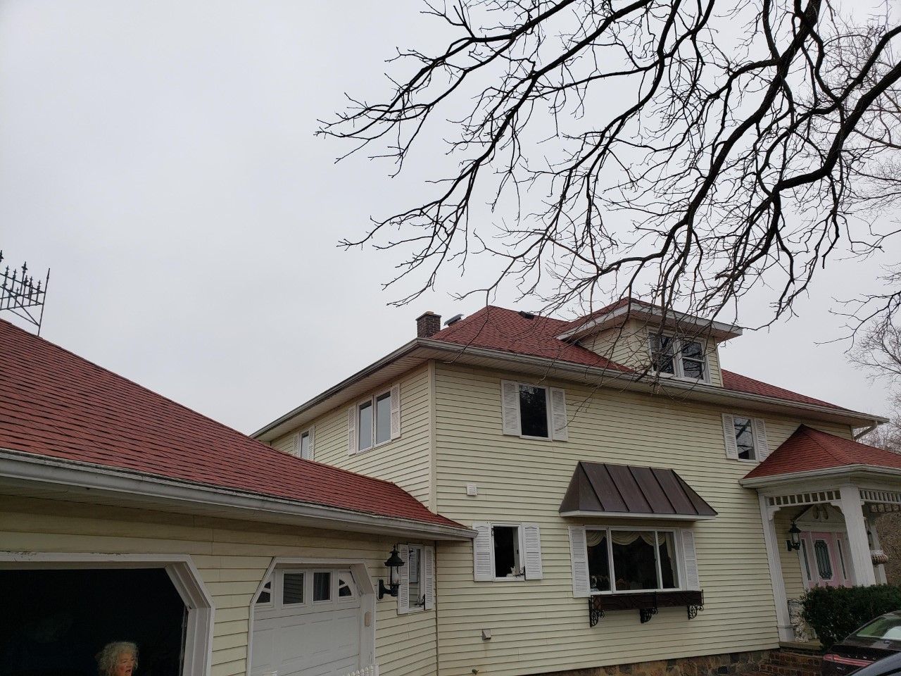 A white house with a red roof and a garage