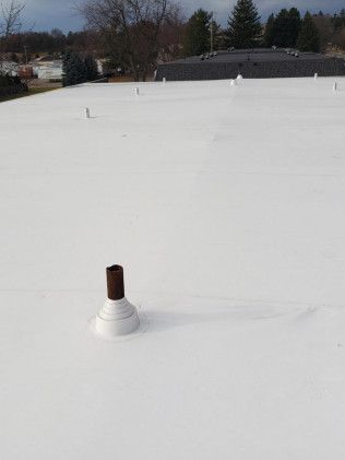 A white roof with a chimney on top of it.