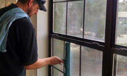 Man wiping window - Residential and Commercial Window Cleaning