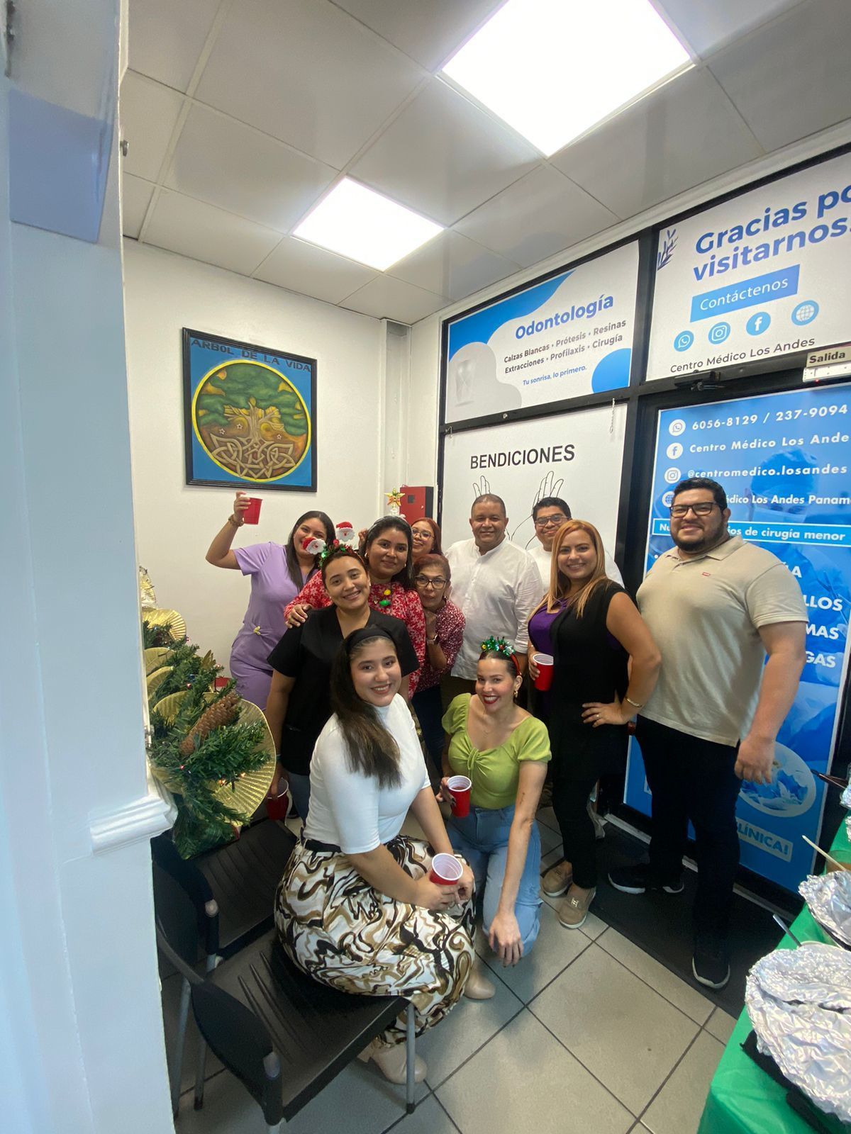 Cinco mujeres con trajes coloridos posan dentro de una oficina bien iluminada.