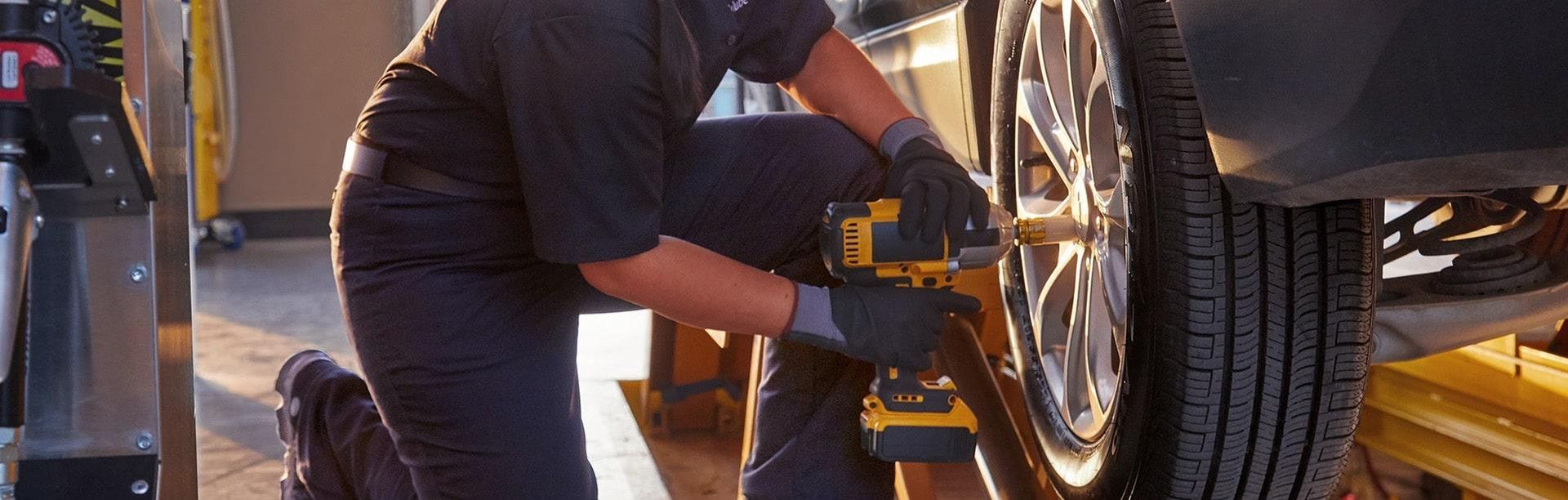 A man is working on a car wheel in a garage  | JB Auto CARE