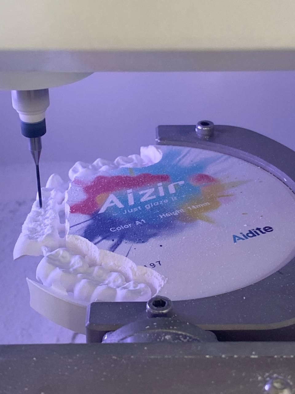 Un dentista está trabajando en un modelo de dientes con un cepillo.