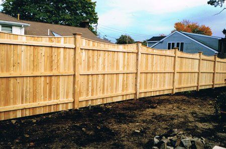 One-inch by four-inch scalloped six-foot board fence with one-inch by two-inch strip cap