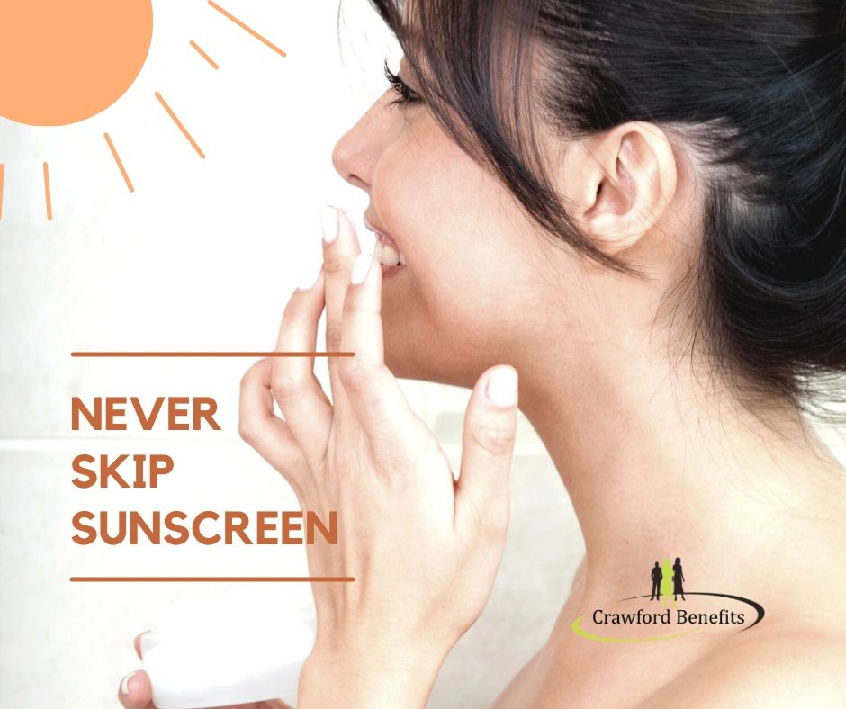 A woman is applying sunscreen to her face