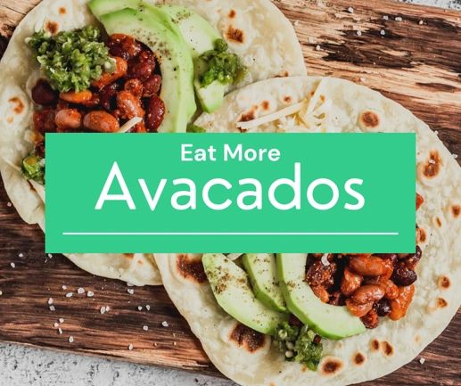 Two tacos with avocados and beans on a wooden cutting board