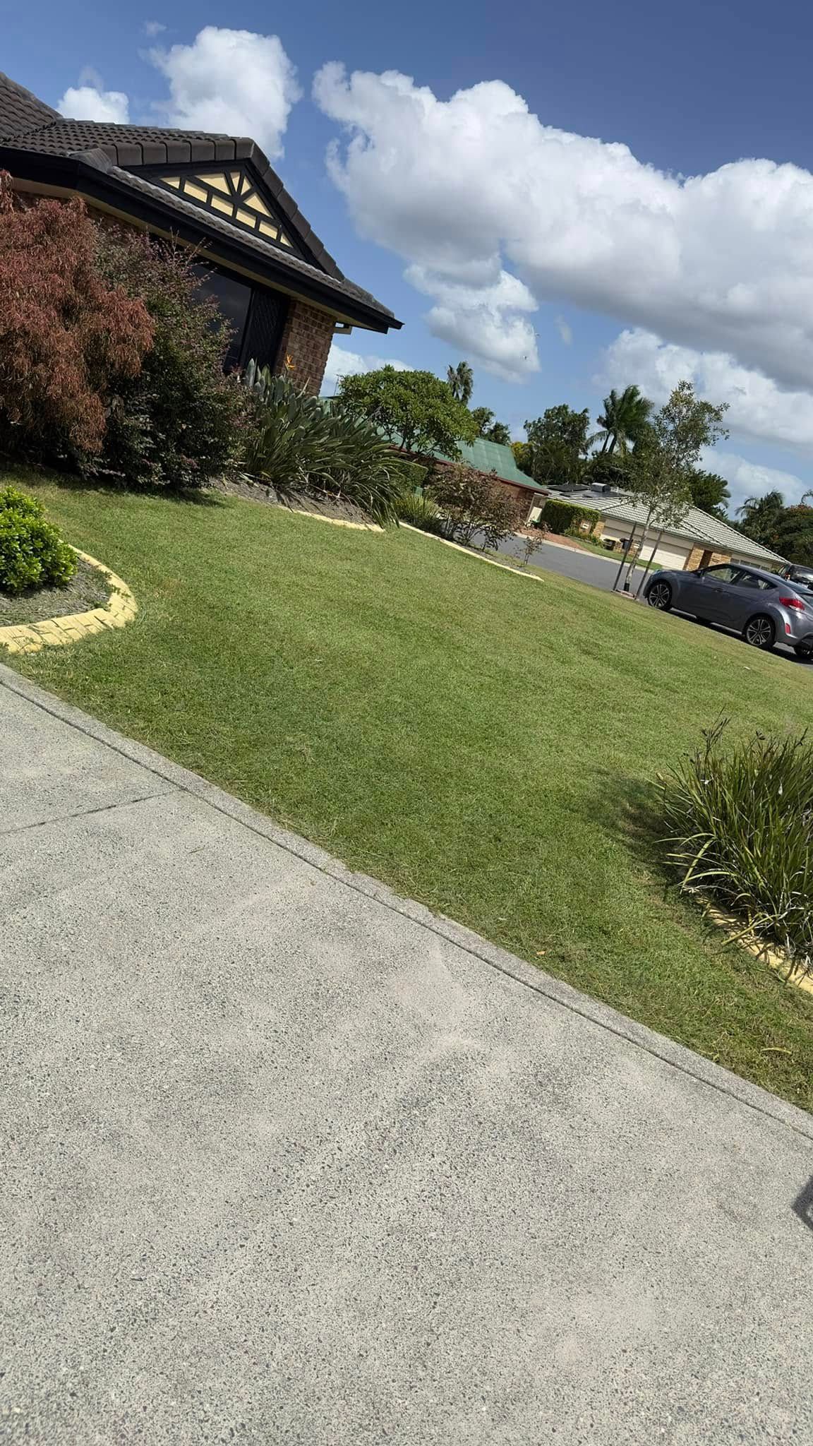 A house with a lot of grass and cars parked in front of it.