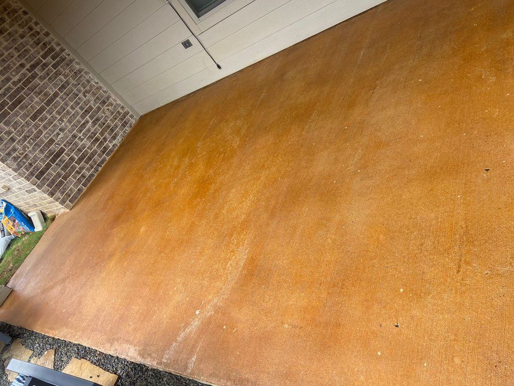 A concrete floor with a brick wall in the background.