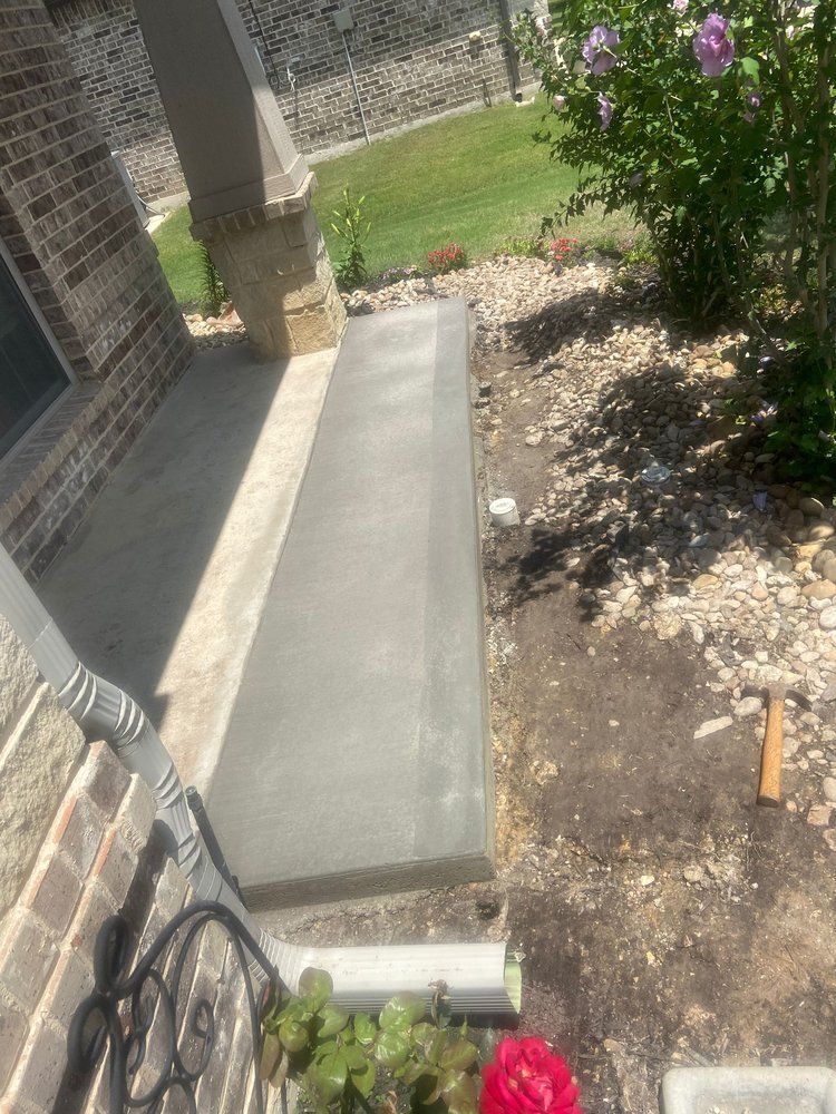 A concrete bench is being built on the side of a house.