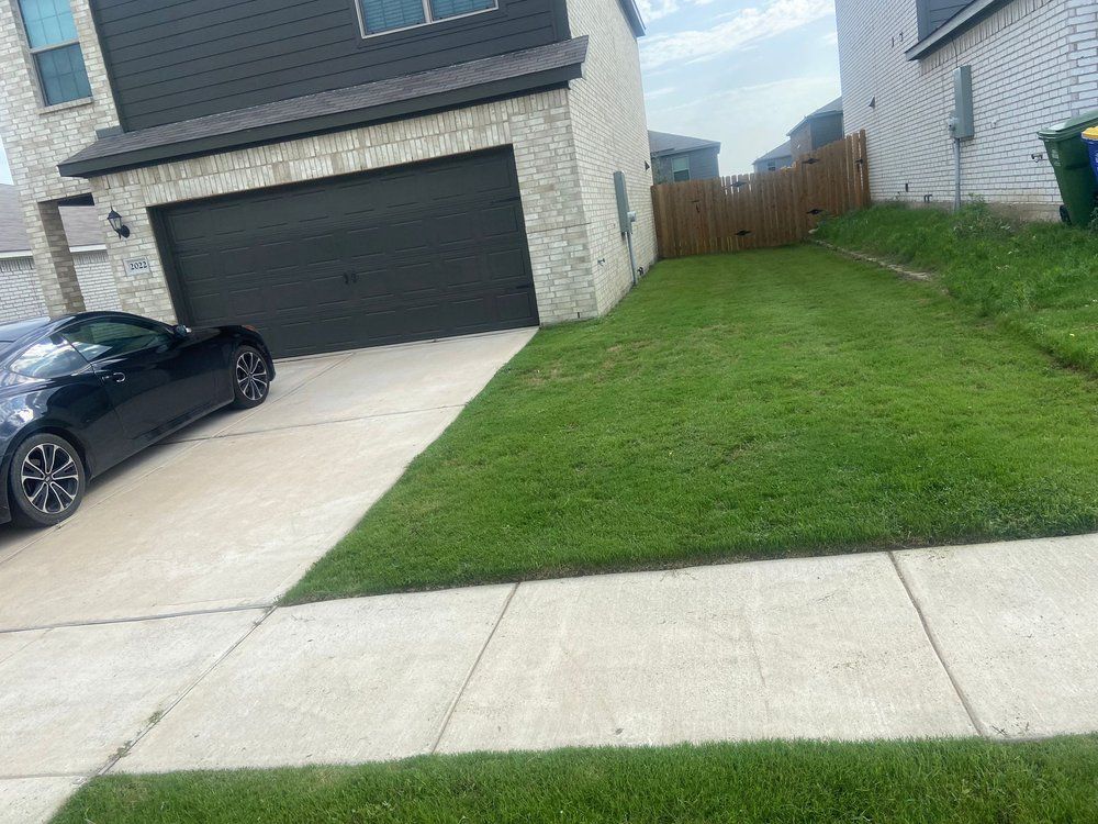 A black car is parked in front of a house.