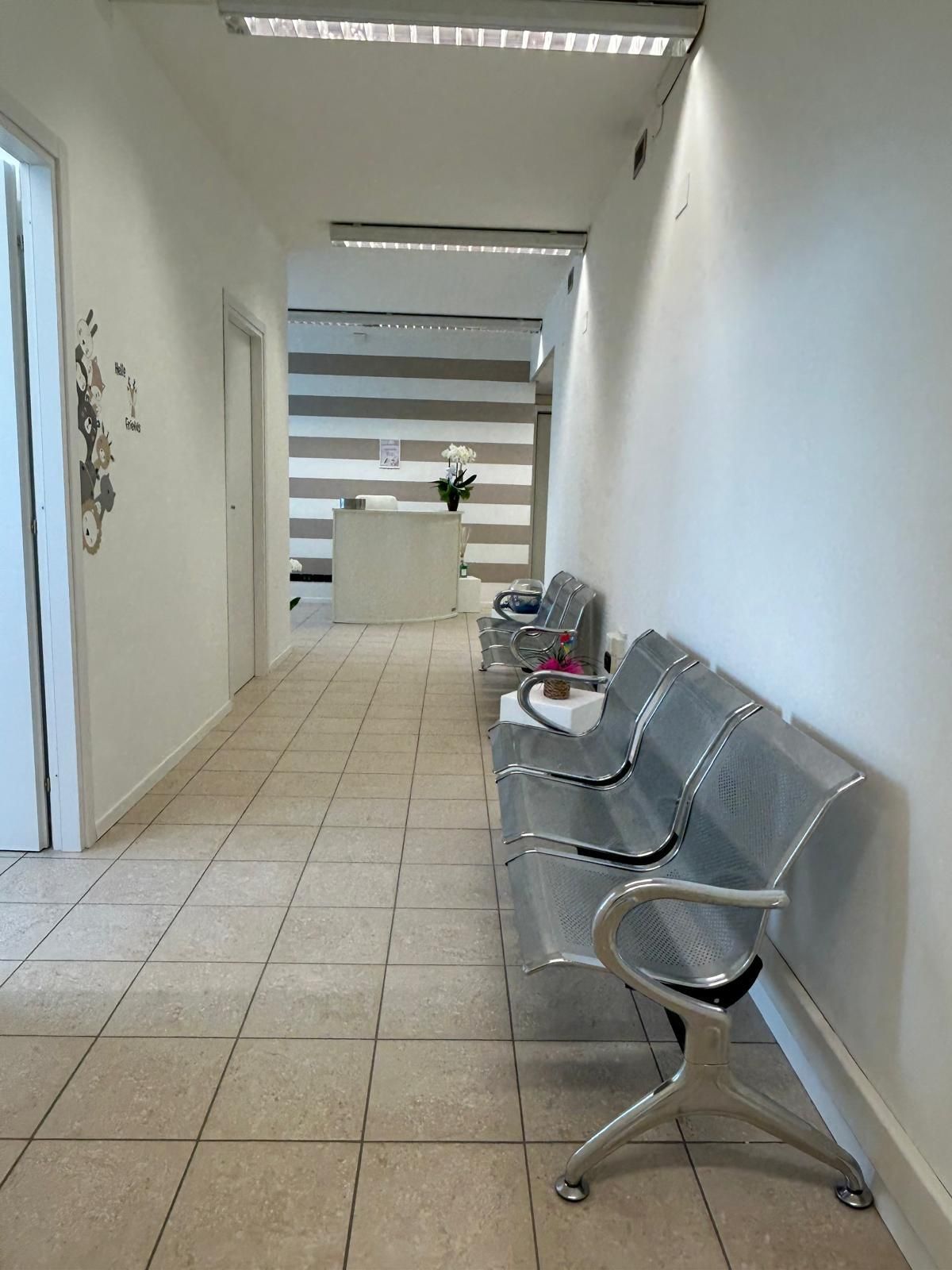 Un lungo corridoio con una fila di panche