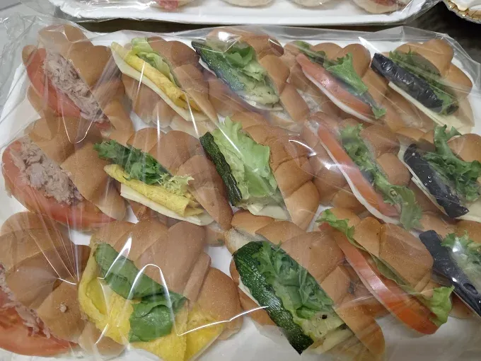 Vassoio di mini panini assortiti avvolti nella plastica.