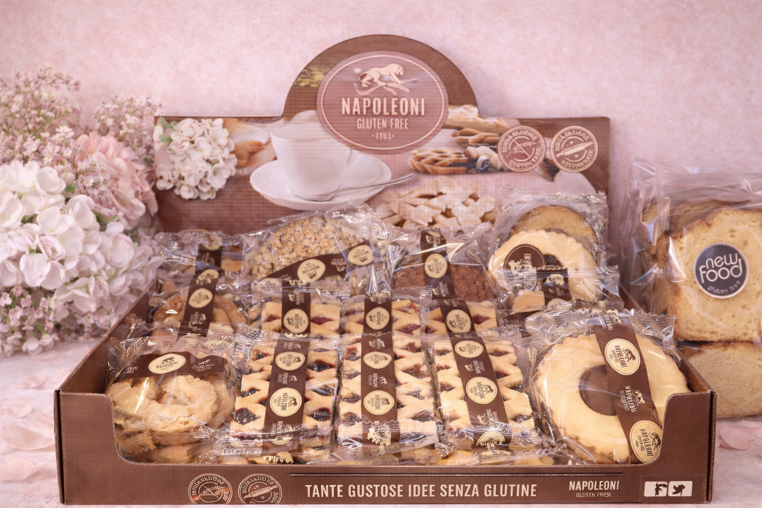 Esposizione di prodotti da forno senza glutine, tra cui biscotti e torte, in una scatola decorativa con il logo del marchio.