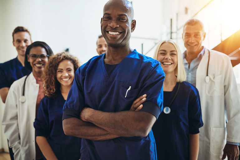 A group of doctors and nurses are posing for a picture in a hospital.