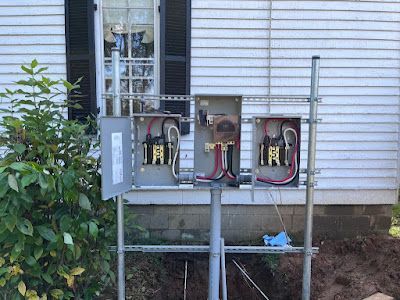 A white house with a bunch of electrical boxes on the side of it.