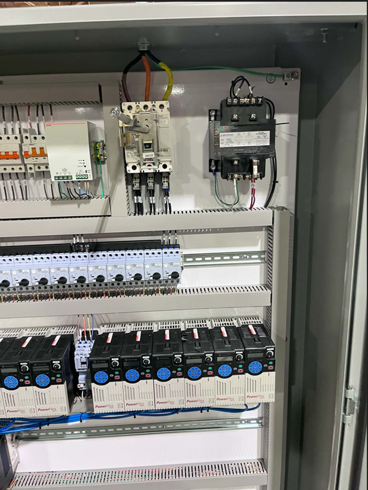 A close up of a electrical panel with a lot of wires coming out of it.