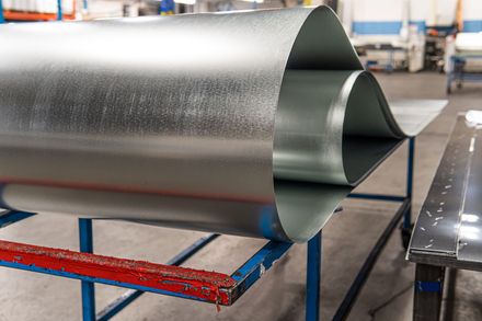 A roll of metal is sitting on top of a table in a factory.