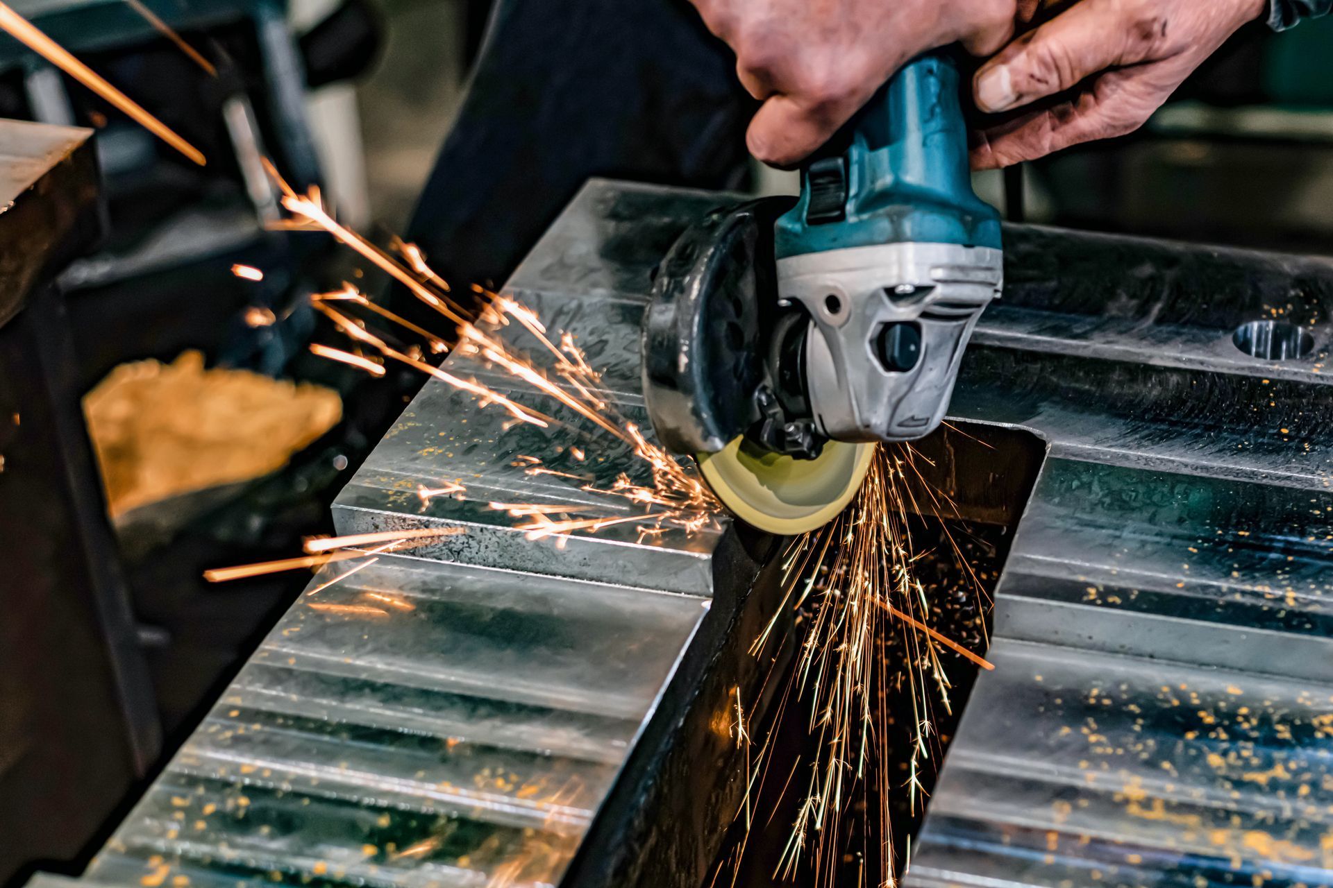 A man polishing/deburring a block of metal