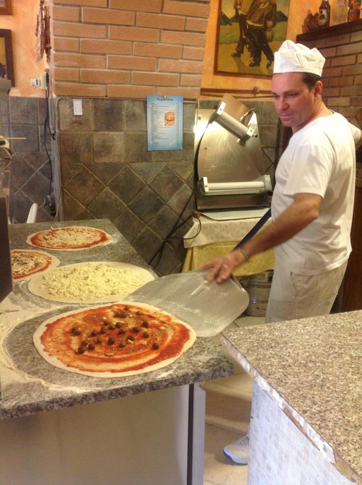 preparazione di pizze con pomodoro e mozzarella