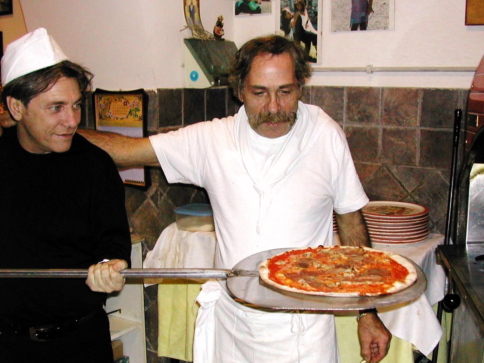 pizzaiolo con pizza sulla pala