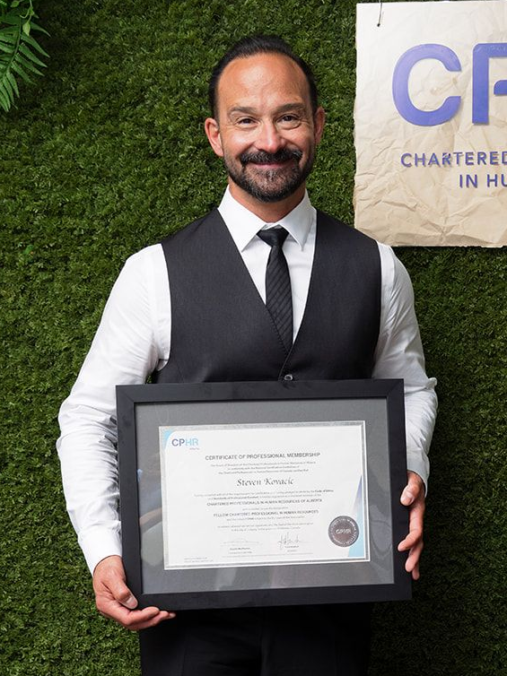 A woman in a blue jacket and white shirt smiles for the camera