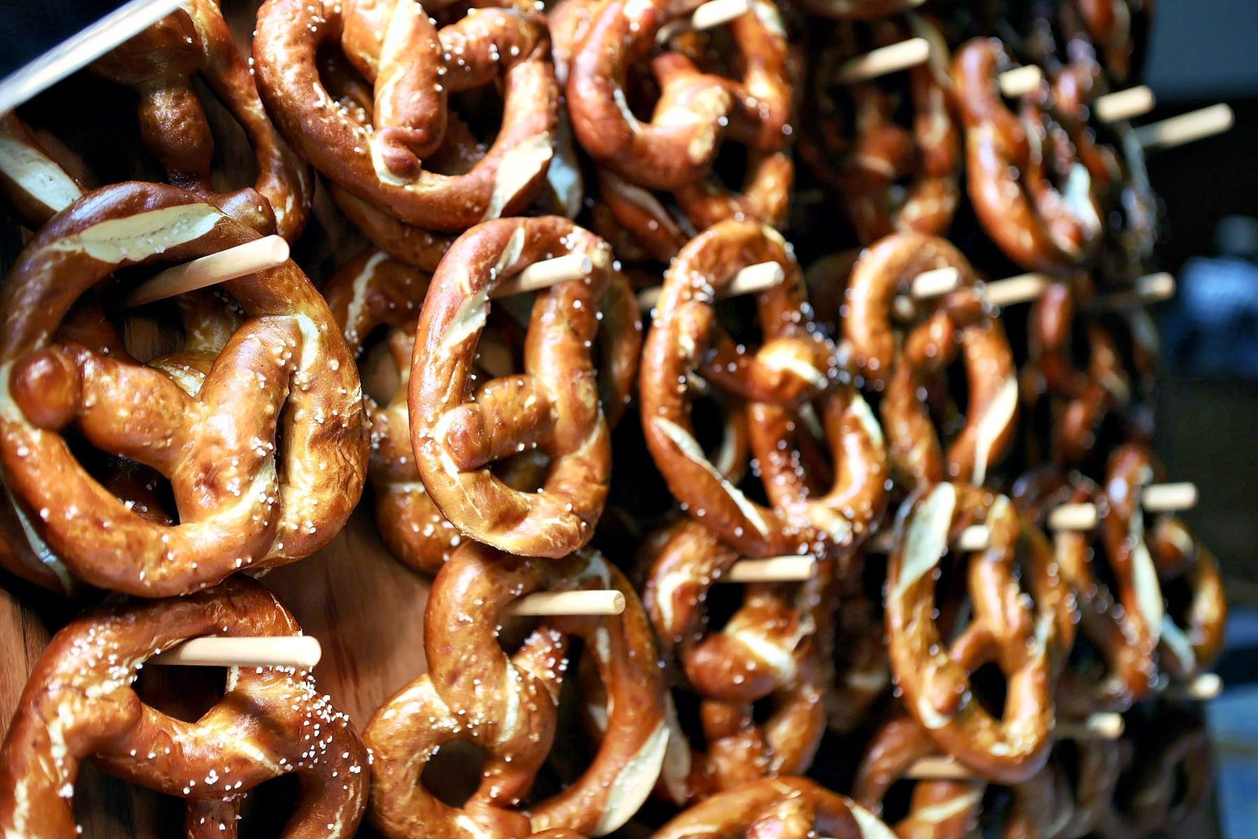 A bunch of pretzels are stacked on top of each other on sticks.