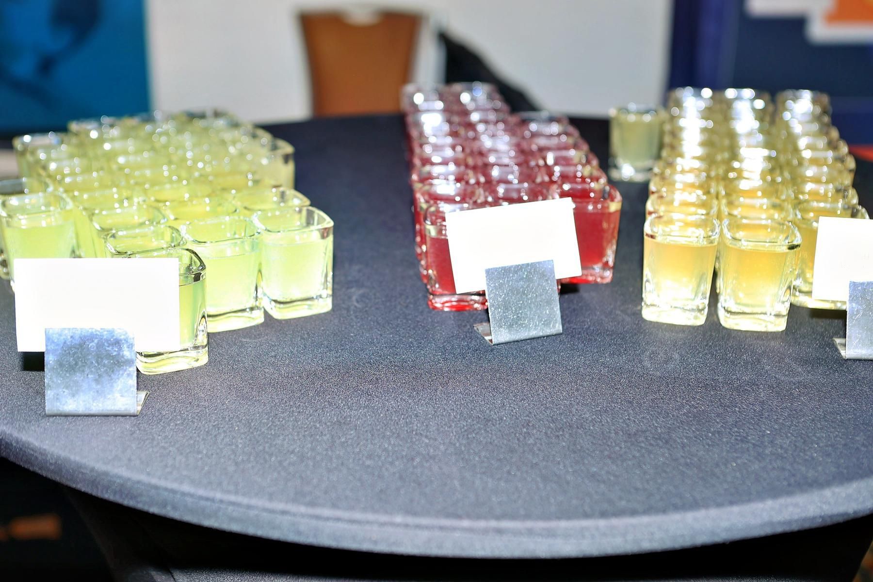 A table full of shot glasses with labels on them