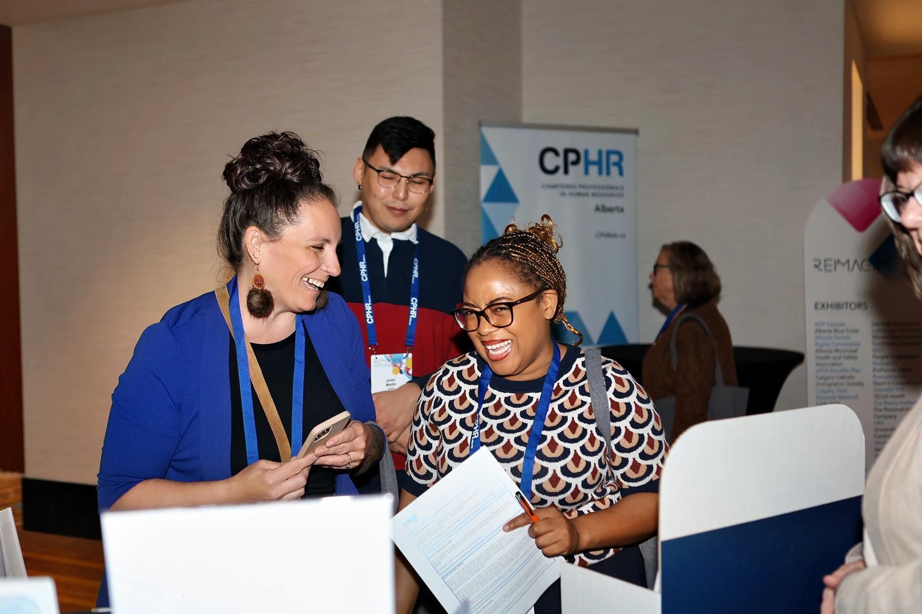 A group of people are standing around a table with a sign that says cphr on it.