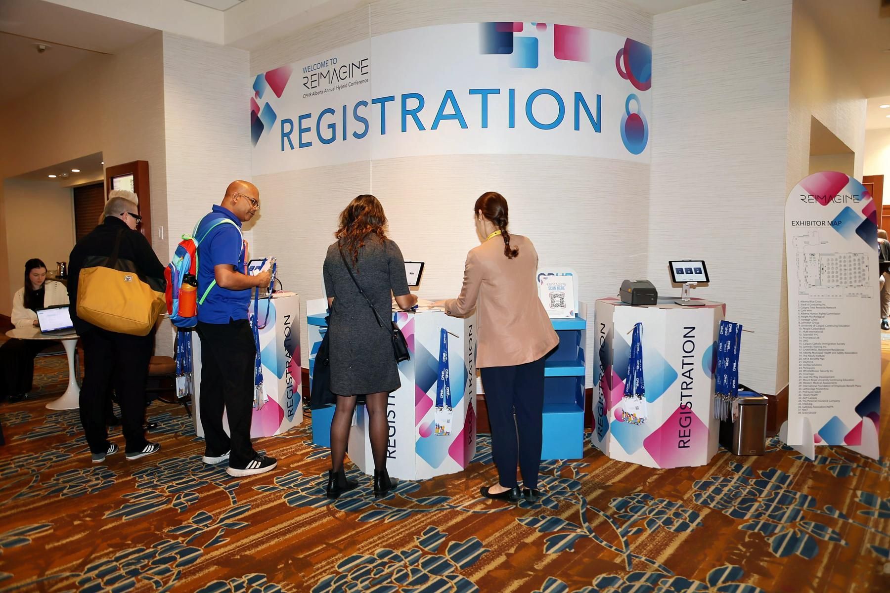 A group of people are standing in front of a registration booth.