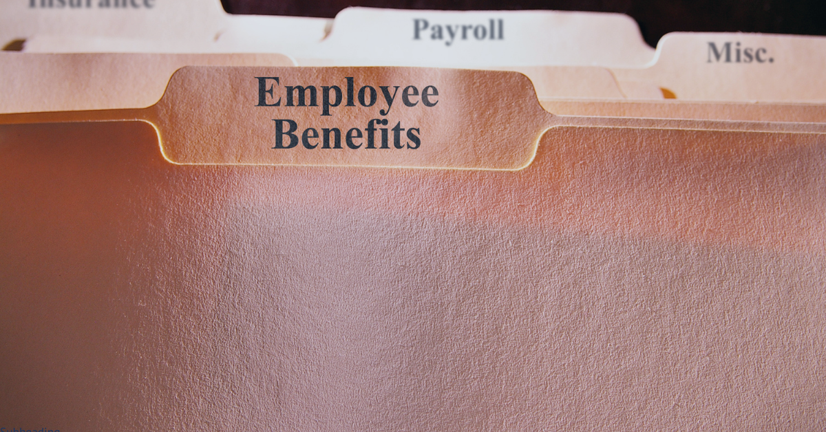 A close up of a file folder labeled employee benefits.