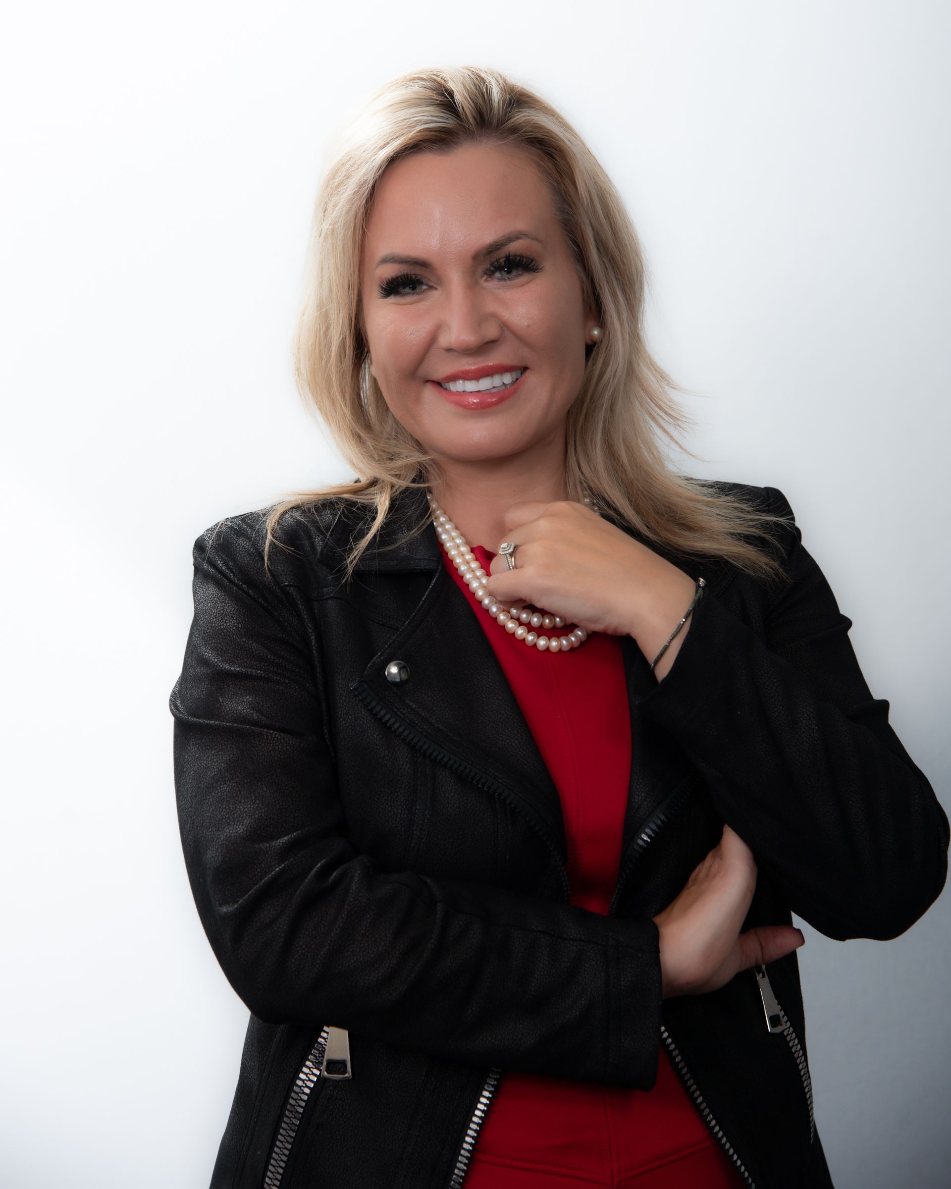 A woman wearing a black leather jacket and a red shirt