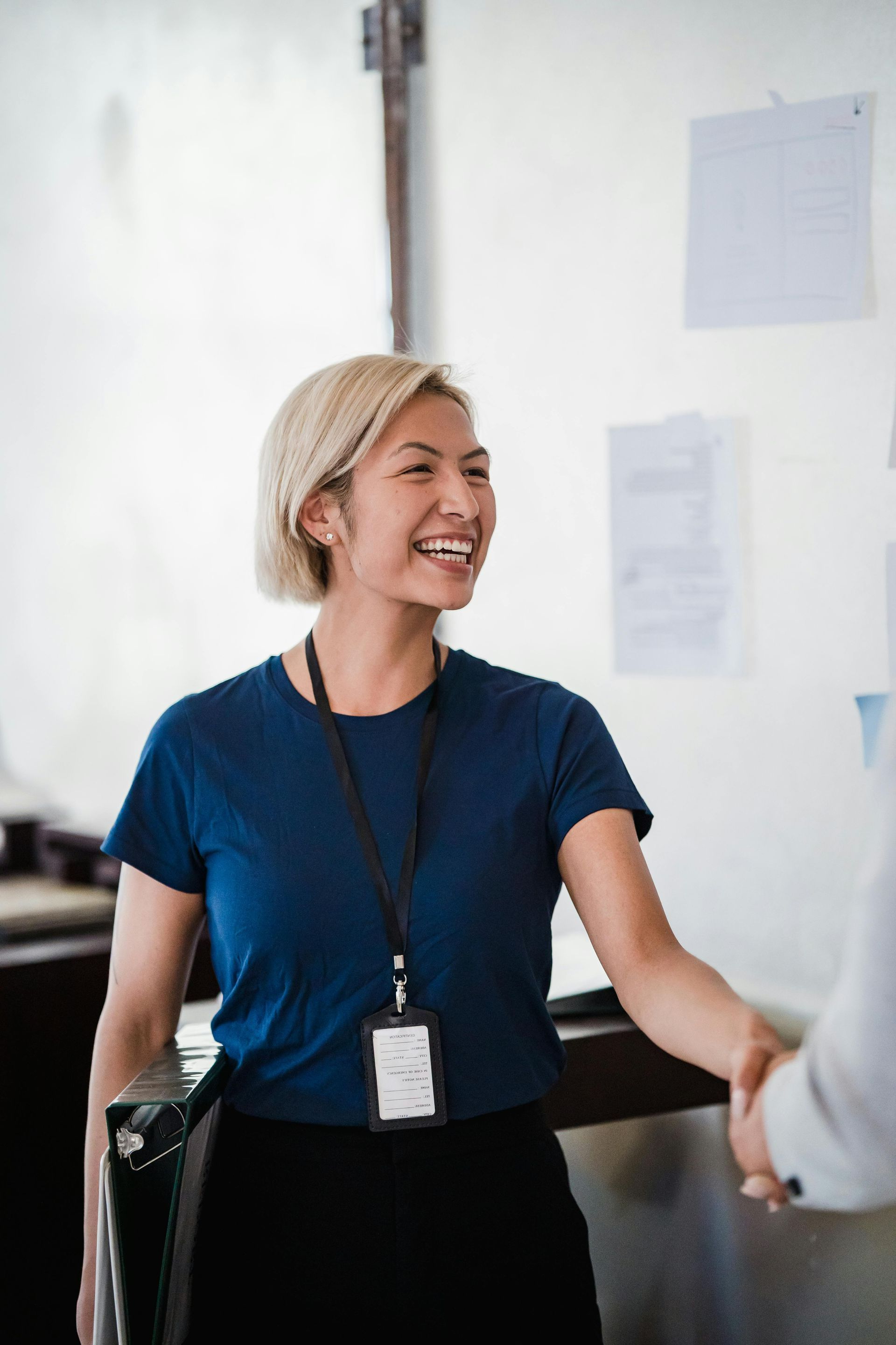 A woman is shaking hands with a man in an office.