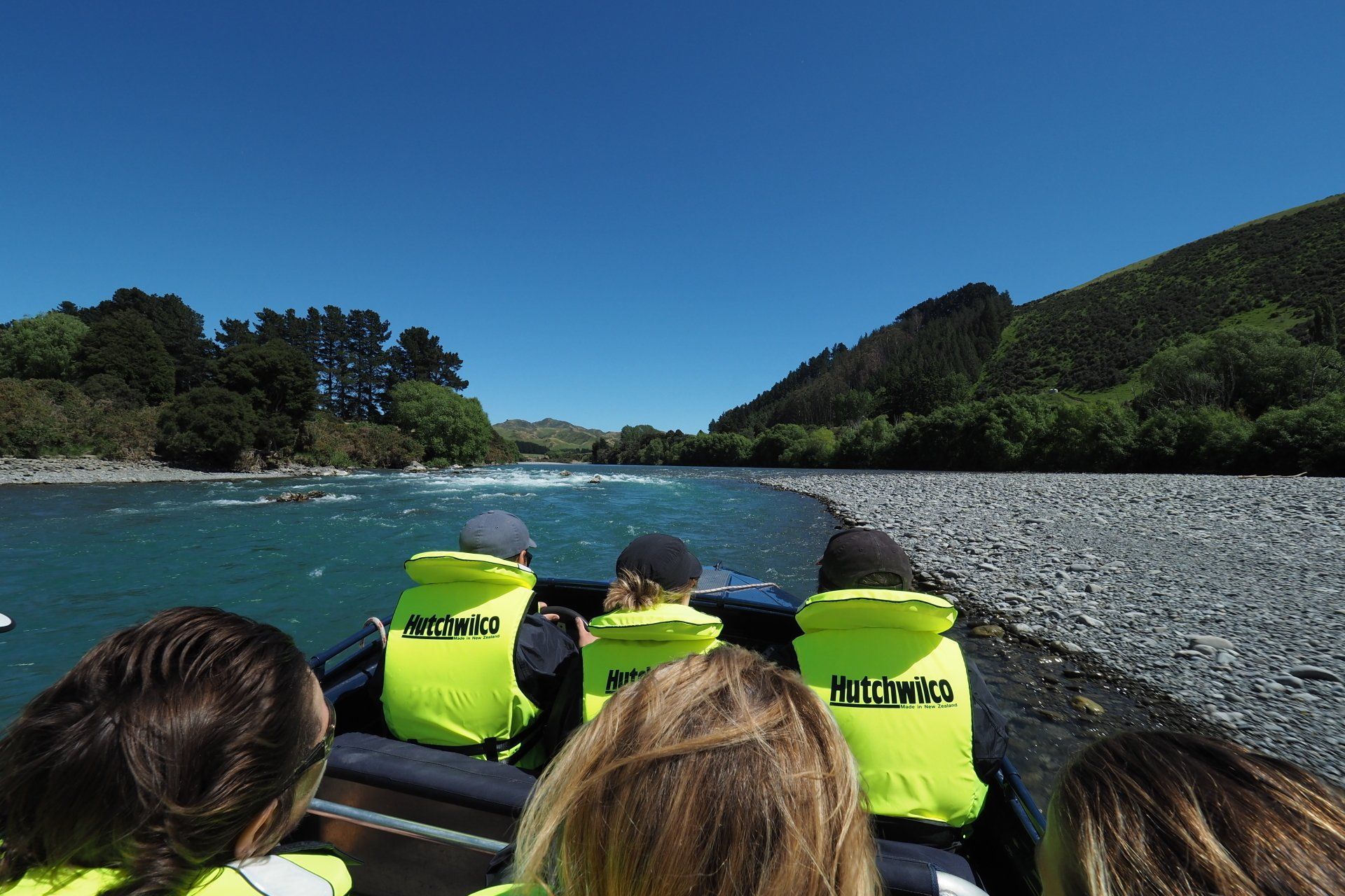 A group of people on a boat wearing yellow vests that say buzz whale