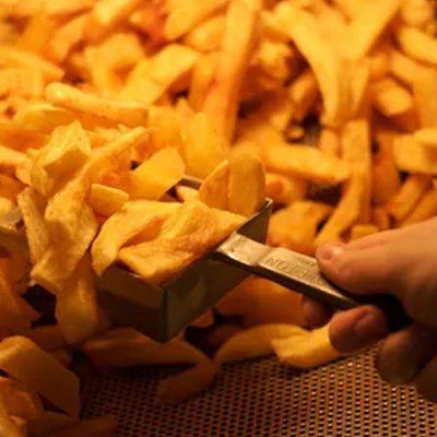 scooping freshly cooked chips from the warmer unit