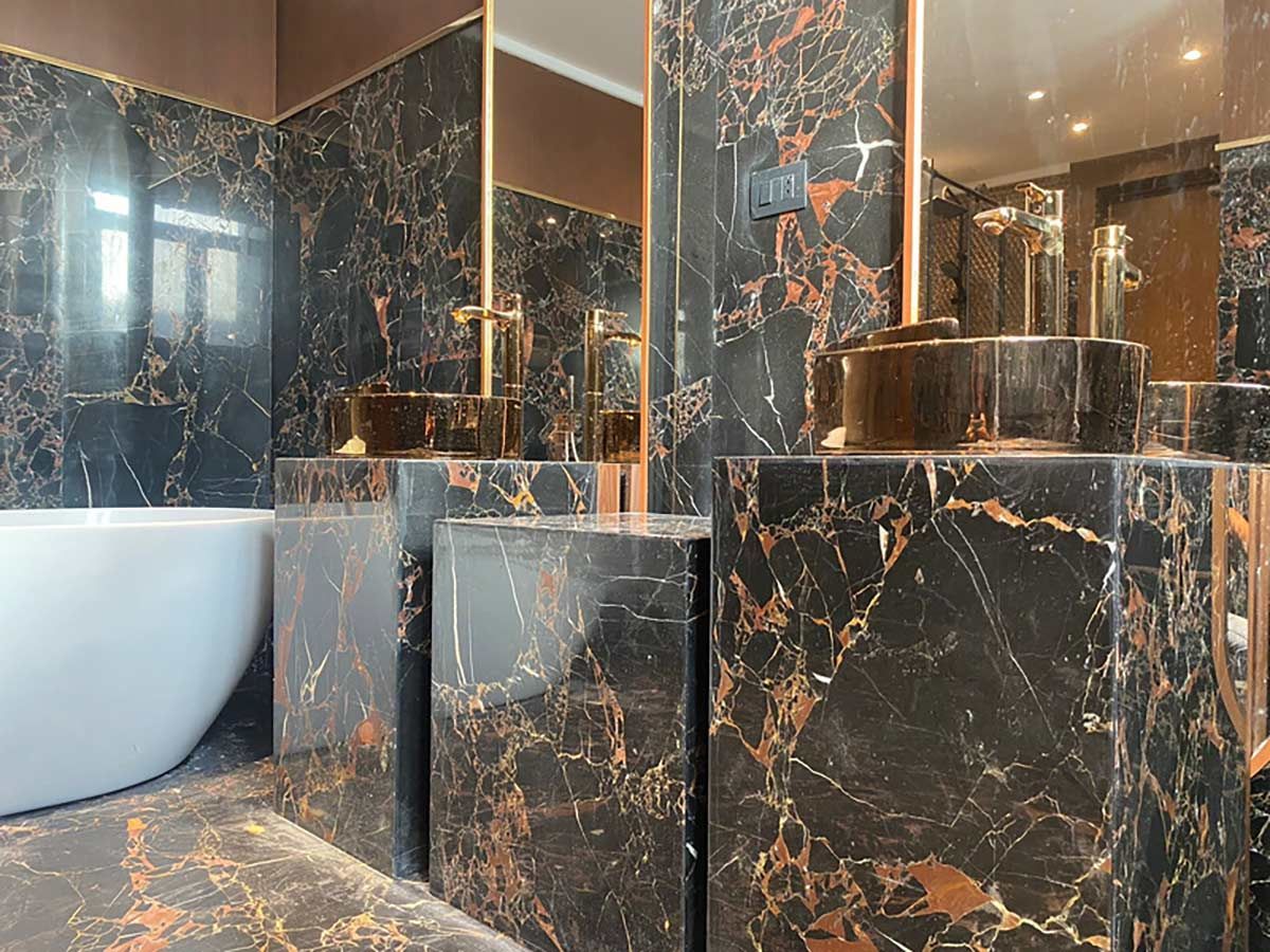 A bathroom with two sinks , a bathtub and a mirror.